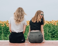 אישה עם משקפי שמש ואישה עם חולצה לבנה